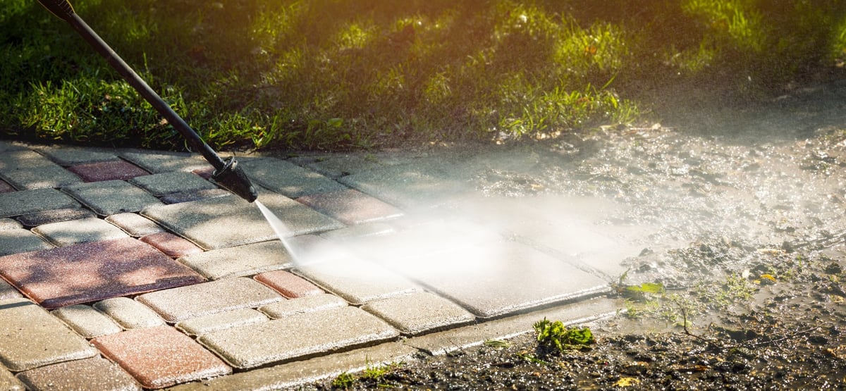 Block pavement being pressure washed